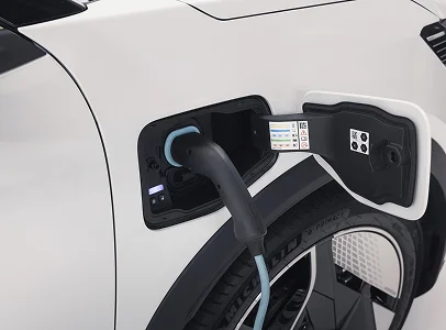 Gros plan d'une voiture électrique blanche en charge avec un câble branché à Brissac Quince dans le Maine-et-Loire 49