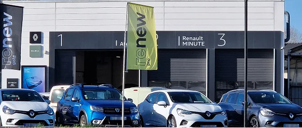 Façade d'un atelier Renault avec trois entrées de garage numérotées, l'une ouverte sur des voitures à Brissac Quince dans le Maine-et-Loire 49